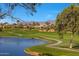 Picturesque golf course with a lake, well-manicured greens, and scenic mountain views on a sunny day at 7272 E Gainey Ranch Rd # 23, Scottsdale, AZ 85258