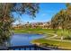 Scenic view of the golf course and a lake with mountain views in the background, framed by trees at 7272 E Gainey Ranch Rd # 23, Scottsdale, AZ 85258