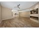 Open-concept living area with fireplace, tv, wood flooring and easy access to the kitchen at 7272 E Gainey Ranch Rd # 23, Scottsdale, AZ 85258