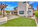 Spacious backyard featuring a well-maintained lawn, jacuzzi, outdoor kitchen, covered patio, and modern exterior design at 826 E Buist Ave, Phoenix, AZ 85042