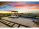 Backyard oasis with pool, spa, outdoor kitchen, and stunning sunset views at 826 E Buist Ave, Phoenix, AZ 85042