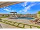 Stunning backyard with pool, spa, outdoor kitchen, pergola, fire feature, and lush landscaping, perfect for relaxation at 826 E Buist Ave, Phoenix, AZ 85042