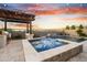 Backyard oasis featuring a pool, jacuzzi, fire pit, and built-in barbecue, perfect for outdoor entertaining at sunset at 826 E Buist Ave, Phoenix, AZ 85042