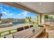 Charming covered patio with dining area and lounge seating, providing serene views of the sparkling pool and fire feature at 826 E Buist Ave, Phoenix, AZ 85042