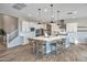 Bright kitchen with a large island, pendant lighting, and wood floors and access to a staircase at 826 E Buist Ave, Phoenix, AZ 85042