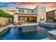A modern backyard with a refreshing pool, spa and lounge chairs under a colorful sunset sky at 826 E Buist Ave, Phoenix, AZ 85042