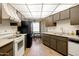Functional kitchen with white appliances, wood cabinets, and adjacent dining area at 10468 W Palmeras Dr, Sun City, AZ 85373