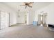 Spacious living room features neutral carpet, ceiling fan, and access to other rooms at 10468 W Palmeras Dr, Sun City, AZ 85373