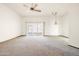 Open-concept living room with fan, light fixture, and sliding door providing ample natural light at 10468 W Palmeras Dr, Sun City, AZ 85373