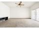 Empty living room with a sliding door to the rear and dark colored wooden shelving to the side at 10468 W Palmeras Dr, Sun City, AZ 85373