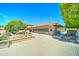 A well-kept community building with a red tile roof, neat landscaping, and a welcoming entrance, surrounded by mature trees at 111 S Greenfield Rd # 547, Mesa, AZ 85206
