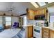 Bright kitchen with white appliances, a breakfast bar, and wood cabinets with a sun roof for natural lighting at 111 S Greenfield Rd # 547, Mesa, AZ 85206