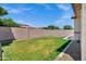 Large, grassy backyard featuring stone accents, privacy fence and firepit. A perfect space for outdoor living at 1272 W Joshua Tree Ave, Queen Creek, AZ 85140