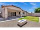An expansive backyard with a stone fire pit, covered patio, and lush lawn for outdoor enjoyment at 1272 W Joshua Tree Ave, Queen Creek, AZ 85140