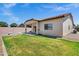 This home's backyard features a cozy covered patio, green lawn, and privacy fencing for a relaxing outdoor space at 1272 W Joshua Tree Ave, Queen Creek, AZ 85140