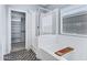 Bright bathroom features bathtub, glass enclosed shower, patterned floors, and walk-in closet at 1272 W Joshua Tree Ave, Queen Creek, AZ 85140