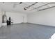 Spacious garage features epoxy floors and utility sink and door to exterior at 1272 W Joshua Tree Ave, Queen Creek, AZ 85140