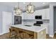 Kitchen features a center island, stainless steel appliances, and modern pendant lighting at 1272 W Joshua Tree Ave, Queen Creek, AZ 85140