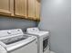 Laundry room featuring modern appliances and storage cabinets for convenience at 1272 W Joshua Tree Ave, Queen Creek, AZ 85140