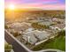 Modern community with solar panels, fenced yards, and desert landscaping at sunset, aerial view at 13820 W Weaver Ct, Litchfield Park, AZ 85340