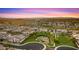 Sunset aerial of a Primary planned community with green spaces, basketball court, and lush landscaping at 13820 W Weaver Ct, Litchfield Park, AZ 85340