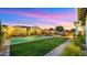 Expansive backyard with a sparkling pool, manicured artificial turf, and a cozy seating area for relaxing evenings at 13820 W Weaver Ct, Litchfield Park, AZ 85340
