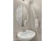 Powder room with pedestal sink, oval mirror, and decorative towel at 13820 W Weaver Ct, Litchfield Park, AZ 85340