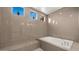 Luxurious bathroom with a large soaking tub, neutral tile, and sleek fixtures providing a relaxing experience at 13820 W Weaver Ct, Litchfield Park, AZ 85340