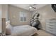 Cozy bedroom with a ceiling fan, window, dresser, and a piece of exercise equipment at 13820 W Weaver Ct, Litchfield Park, AZ 85340