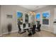 Modern dining room with a black glass table, seating for six, and bright windows offering great natural light at 13820 W Weaver Ct, Litchfield Park, AZ 85340