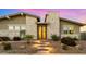 Inviting front entrance with a decorative door, stone accents, and landscaped surroundings, creating a warm welcome at 13820 W Weaver Ct, Litchfield Park, AZ 85340