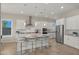 Modern kitchen with white cabinets, stainless steel appliances, island with seating, and recessed lighting at 13820 W Weaver Ct, Litchfield Park, AZ 85340