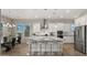 Bright, open kitchen features white cabinets, a large island with seating, and stainless steel appliances at 13820 W Weaver Ct, Litchfield Park, AZ 85340