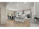 Bright kitchen with white cabinets, stainless steel appliances, island seating, and a view to the dining area at 13820 W Weaver Ct, Litchfield Park, AZ 85340