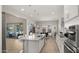 Elegant kitchen with white cabinets, stainless steel appliances, a center island, and seamless flow to dining at 13820 W Weaver Ct, Litchfield Park, AZ 85340