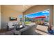 Outdoor living area with a TV, fireplace, and stylish seating, ideal for entertaining at 13820 W Weaver Ct, Litchfield Park, AZ 85340