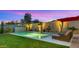 Inviting pool with turf, block fencing, waterfall feature, and desert landscaping for a relaxing outdoor oasis at 13820 W Weaver Ct, Litchfield Park, AZ 85340