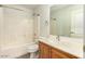 A clean bathroom featuring a shower-tub combination with white tile and a wooden vanity with a white countertop at 15460 W Mescal W St, Surprise, AZ 85379