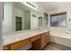 Bathroom with a large vanity area, soaking tub, walk in shower, and window with blinds at 15460 W Mescal W St, Surprise, AZ 85379