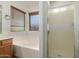 Bathroom showcasing a soaking tub with window and blinds along with a glass enclosed shower stall at 15460 W Mescal W St, Surprise, AZ 85379