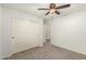 Carpeted bedroom with closet, ceiling fan, and doorway leading to hall at 15460 W Mescal W St, Surprise, AZ 85379