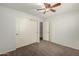 Carpeted bedroom with ceiling fan, closet, and neutral wall color at 15460 W Mescal W St, Surprise, AZ 85379