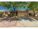 Inviting front exterior with mature shade trees, two-car garage, and desert landscaping at 15460 W Mescal W St, Surprise, AZ 85379