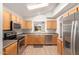 Modern kitchen with stainless steel appliances, tile floors, and wood cabinets at 15460 W Mescal W St, Surprise, AZ 85379