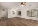 Bright and airy living room with ceiling fan, wood-look floors, and picture windows at 15460 W Mescal W St, Surprise, AZ 85379