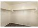 Walk-in closet features built in shelving with wooden rods for hanging at 15460 W Mescal W St, Surprise, AZ 85379