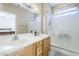 Bright bathroom features double sinks, wood cabinetry and a glass enclosed shower at 15960 W Indigo Ln, Surprise, AZ 85374