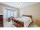 Bedroom with a bay window, ceiling fan, wooden desk, and traditional furniture creating a comfortable atmosphere at 15960 W Indigo Ln, Surprise, AZ 85374