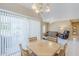 Bright dining space with sliding glass doors, modern chandelier, and open view into the living area with comfortable seating at 15960 W Indigo Ln, Surprise, AZ 85374