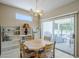 Dining area with a wooden table, chairs, decorative chandelier, and sliding glass doors leading to an outdoor patio at 15960 W Indigo Ln, Surprise, AZ 85374